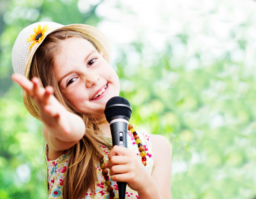 pretty little girl with the microphone in her hands - outdoor