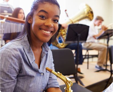 smiling girl playing a saxophone during class