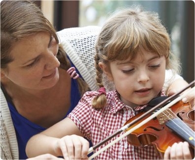 teacher tutoring a young girl to play violin