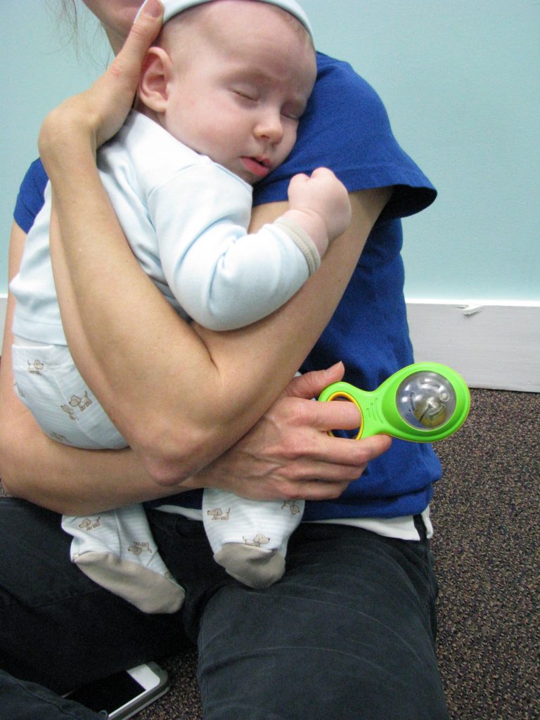 baby and mom cuddle and rock to music