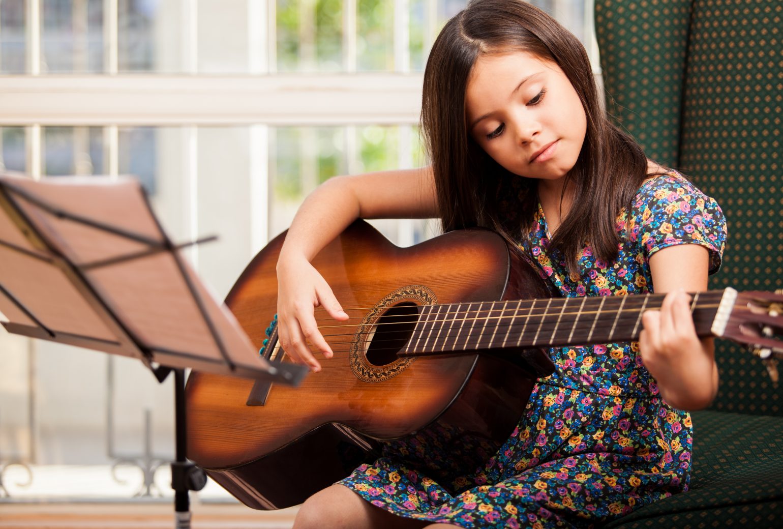 Girl practicing guitar for guitar lessons