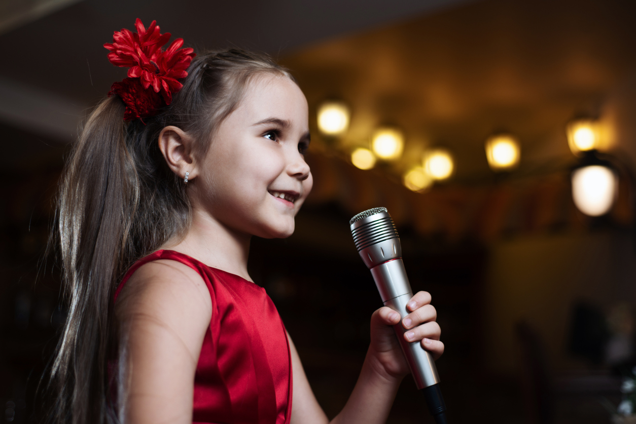 Girl who had voice lessons singing on stage